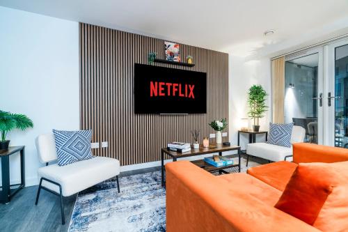 a living room with an orange couch and two chairs at Stylish Decor Close to Vibrant O2, Canary Wharf & Isle of Dogs in London