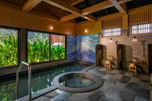 a bathroom with a tub in the middle of a pool at Tana Spring Resort Mae Chan in Chiang Rai