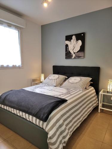 - une chambre avec un lit avec des draps rayés et une fenêtre dans l'établissement Bristol Park - parking - 5mn walk from Palais des Festivals, à Cannes