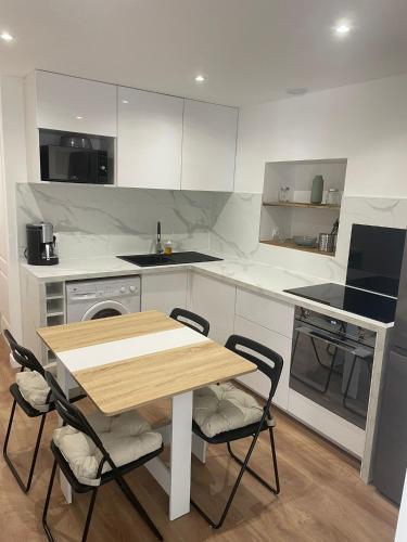 une cuisine avec une table et des chaises en bois dans l'établissement Studio Les Hauteurs de Juziers, à Juziers