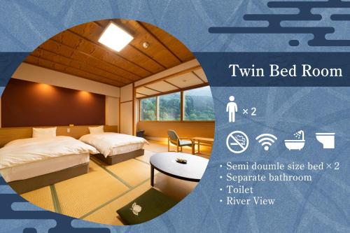 a hotel room with two beds and a table at Kurobe UnazukiOnsen Togen in Kurobe