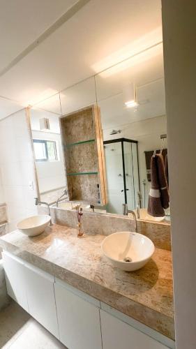 a bathroom with two sinks and a large mirror at Casa e Flat Rio e Praia in Paulista