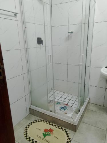 a shower with a glass door on a bathroom at Duminy Guest Lodge in Bellville