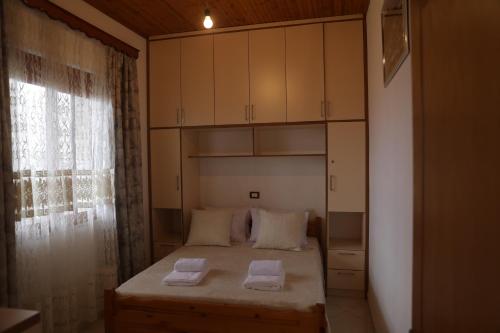 a bedroom with a bed with two towels on it at Villa Selenica Zhitom in Poliçan