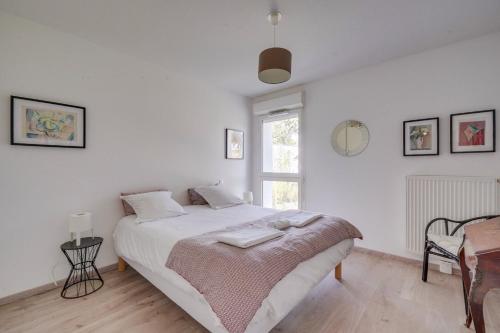 une chambre blanche avec un lit et une fenêtre dans l'établissement Ravissant appartement aux Chartrons avec Parking, à Bordeaux