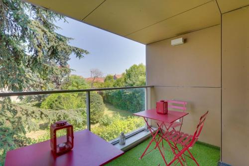 Cette chambre comprend une table et des chaises rouges ainsi qu'une fenêtre. dans l'établissement Ravissant appartement aux Chartrons avec Parking, à Bordeaux