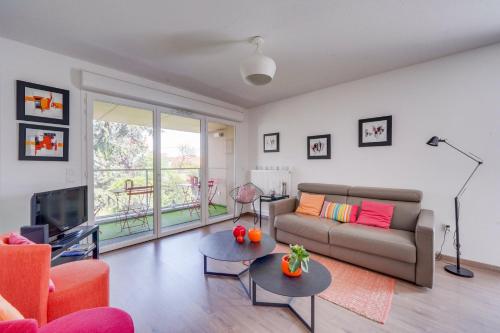 un salon avec un canapé et une télévision dans l'établissement Ravissant appartement aux Chartrons avec Parking, à Bordeaux