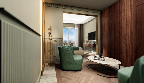 a living room with a green chair and a table at Grand Hotel Bristol in Stresa