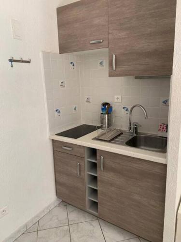 une petite cuisine avec un évier et un comptoir dans l'établissement Studio village naturiste Turquoise, au Cap d'Agde