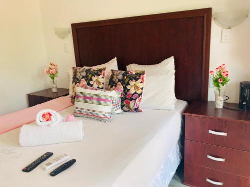 a bedroom with a bed with white sheets and pillows at Thembisiz Guesthouse in Newcastle