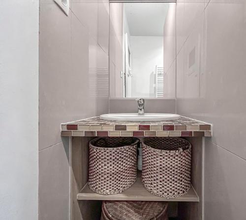 une salle de bain avec un lavabo et un miroir dans l'établissement Lumineux & Élégant Centre Strasbourg, à Strasbourg