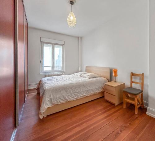 une chambre avec un lit, une fenêtre et une chaise dans l'établissement Lumineux & Élégant Centre Strasbourg, à Strasbourg
