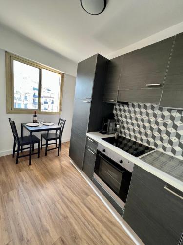 une cuisine avec une table et une salle à manger dans l'établissement Studio cosy et lumineux ,Boulevard Gambetta, Nice, à Nice