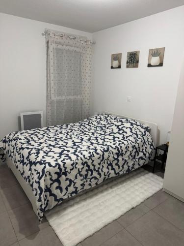 une chambre avec un lit avec une couverture noire et blanche dans l'établissement Beau T2 Arlesien, à Arles
