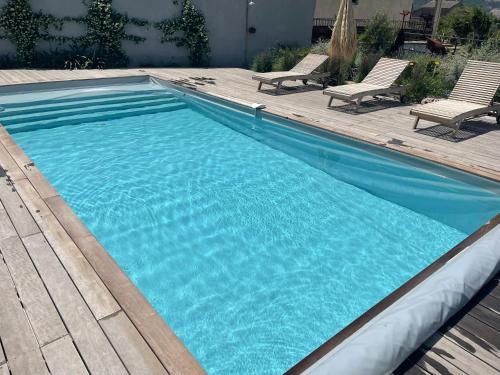 - une piscine d'eau bleue et 2 chaises dans l'établissement Bellu Querciu, à Patrimonio