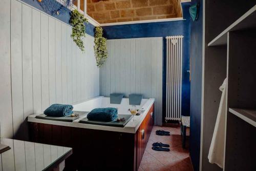 a bath tub with two blue pillows in a bathroom at Cuore 46&48 by Travel with Gianni in Monopoli