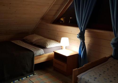 a bedroom with two twin beds and a window at Domki na Mazurach - Rybical 65 in Ryn