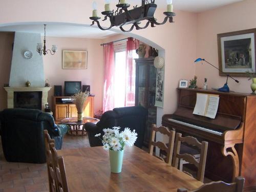 un salon avec une table et un piano dans l'établissement Le clos des oliviers, à Ventabren