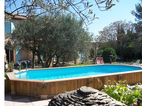 une grande piscine entourée d'une clôture en bois. dans l'établissement Le clos des oliviers, à Ventabren