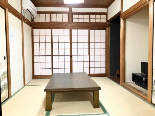 a room with a table in front of a large window at Villa Hineno in Izumi-Sano