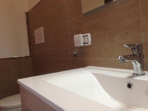 a bathroom with a white sink and a toilet at B&B Maison Rosetta IUN-E4948 in Nuoro