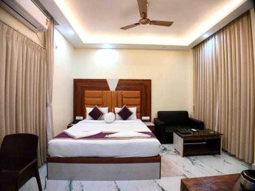 a hotel room with a bed and a chair at Elegant Beach Resort in Mandarmoni