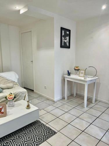 a white room with a bed and a table at Logement accueillant in Gaillon