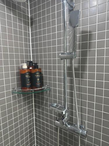 a shower with two shelves in a tiled bathroom at Grape Residence Hotel in Incheon