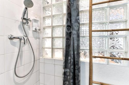 une douche avec un rideau de douche dans une salle de bain dans l'établissement Superb studio au coeur du Panier, à Marseille