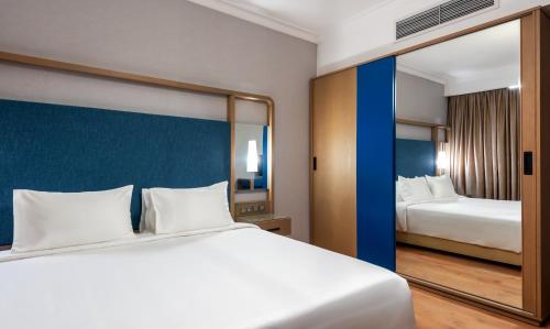 a hotel room with a large bed and a mirror at Nile Suites Plaza Hotel Apartments in Cairo