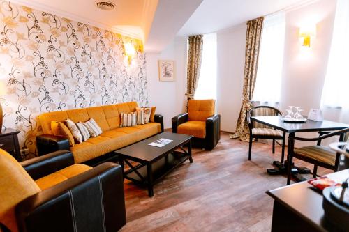 a living room with a couch and chairs and tables at Best Western Plus Lido Hotel in Timişoara
