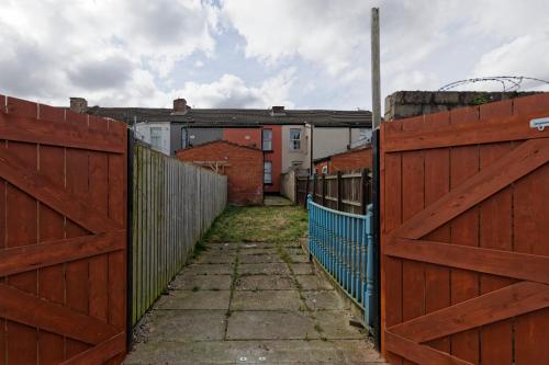 an alley between two fences with houses in the background at Silver Bambu Liverpool Hideaway in Liverpool