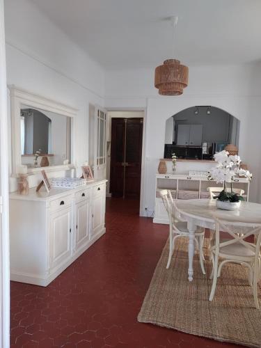 une cuisine blanche avec une table et une salle à manger dans l'établissement Toulon Soleil Et Douceur ll, à Toulon