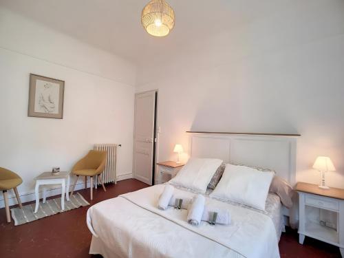 a bedroom with a white bed with two pillows at Toulon Soleil Et Douceur ll in Toulon