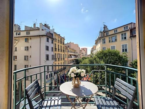 a table with a vase of flowers on a balcony at Toulon Soleil Et Douceur ll in Toulon