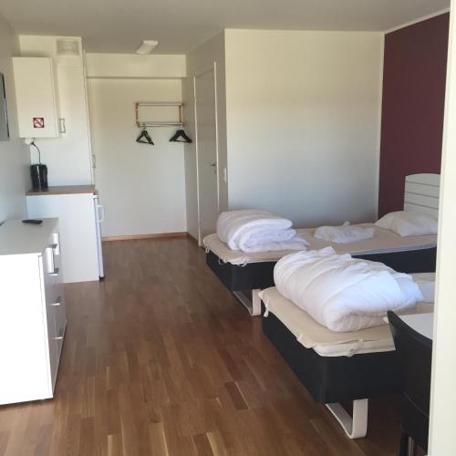 a room with three beds in a room with wood floors at Piteå Golfhotell in Piteå