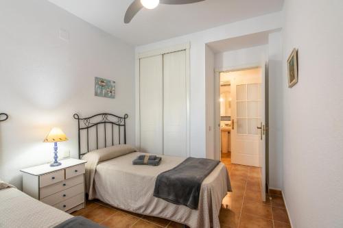 a bedroom with two beds and a lamp on a night stand at Las Dunas - Playa Punta del Moral PLHD141P160 in Punta del moral