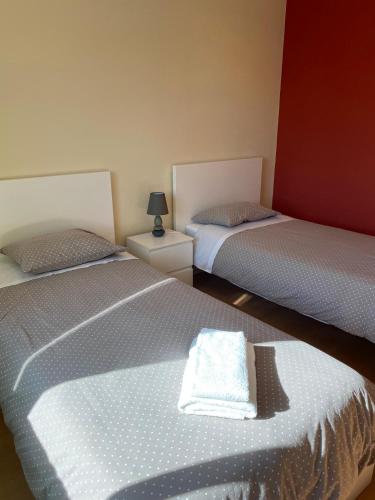 two twin beds in a room with a white towel at Monte Açores in Ferreira do Alentejo