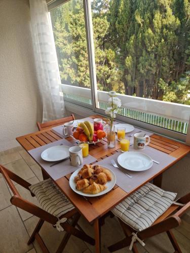 une table en bois avec une assiette de nourriture dessus dans l'établissement Sanary Sur Mer, Soleil Et Douceur I, à Sanary-sur-Mer