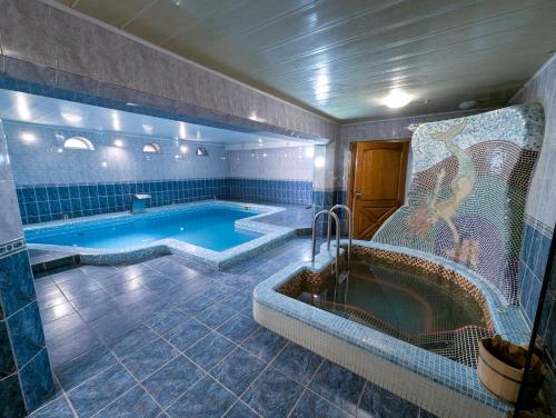 a bathroom with a tub and a swimming pool at Ізумруд in Chop