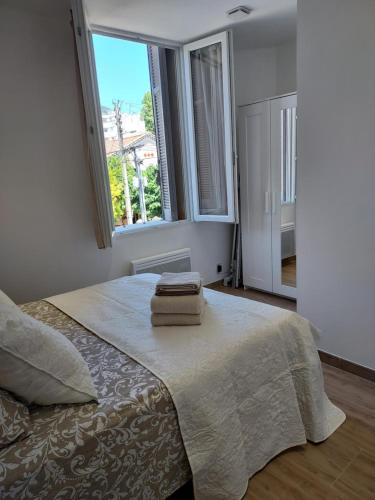 une chambre avec un lit avec deux serviettes dessus dans l'établissement Toulon, Soleil Et Douceur I, à Toulon