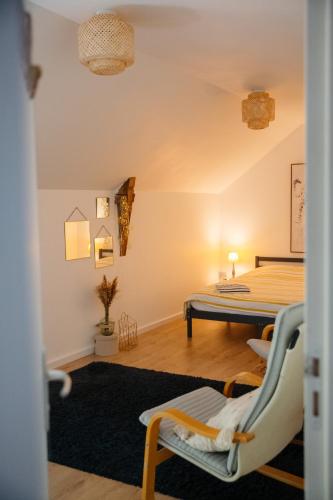 Cette chambre comprend un lit et des chaises. dans l'établissement La Borgnardais - chambres étape tout équipées, à Loutehel