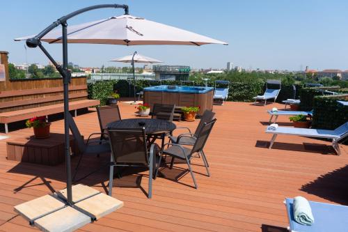 a patio with a table and chairs and an umbrella at Best Western Plus Lido Hotel in Timişoara