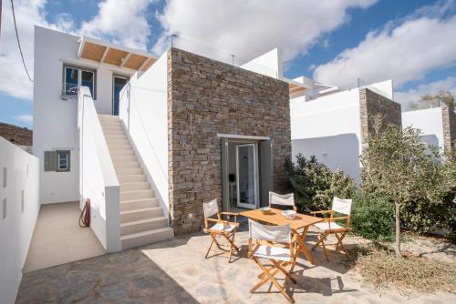 a white house with a table and chairs on a patio at Deluxe Maisonette With Private Jacuzzi in Glifades