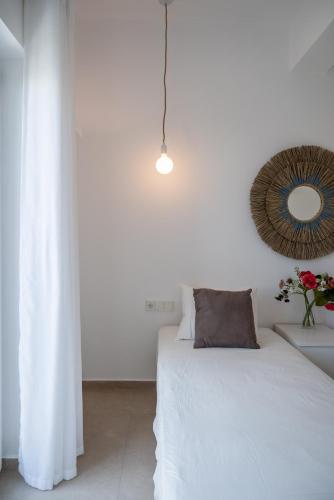 a white bedroom with a bed and a mirror at Deluxe Maisonette With Private Jacuzzi in Glifades