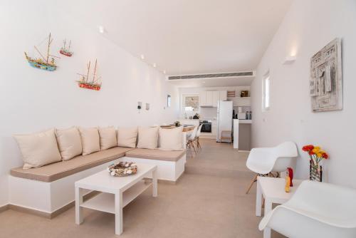 a white living room with a couch and a table at Deluxe Maisonette With Private Jacuzzi in Glifades