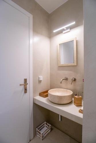 a bathroom with a sink and a mirror at Deluxe Maisonette With Private Jacuzzi in Glifades