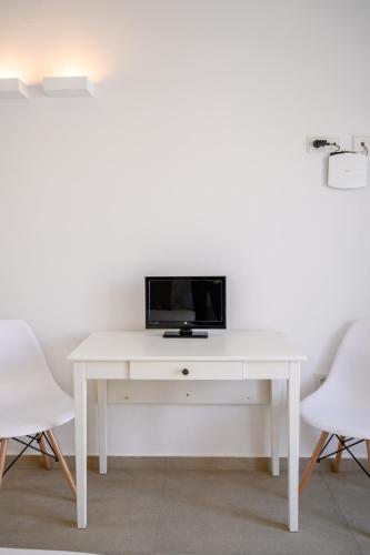 a white desk with a tv on top of it at Deluxe Maisonette With Private Jacuzzi in Glifades