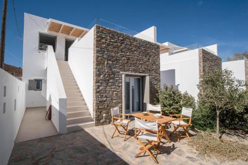 a house with a table and chairs on a patio at Deluxe Maisonette With Private Jacuzzi in Glifades