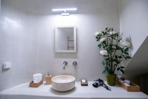 a white bathroom with a sink and a mirror at Deluxe Maisonette With Private Jacuzzi in Glifades
